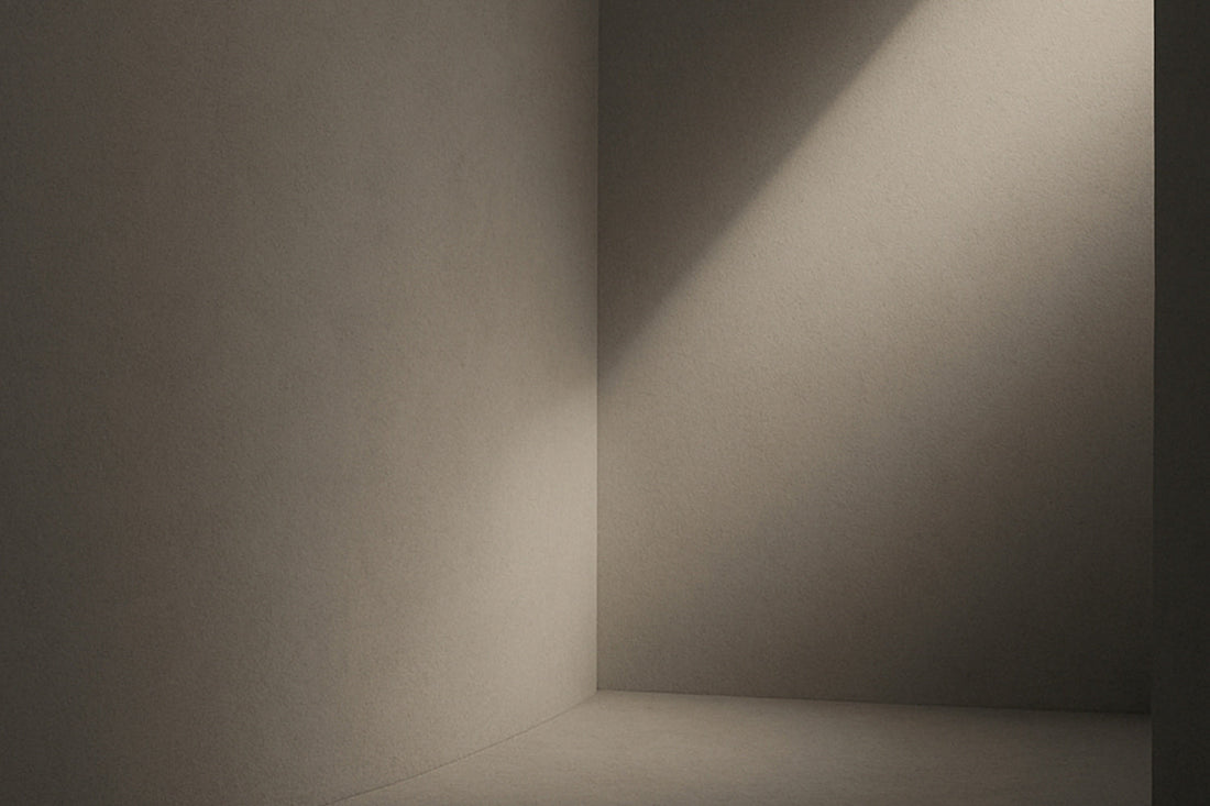 Abstrakter, minimalistisch gestalteter Innenraum mit einer sanften diagonalen Lichtkante auf glatter Fläche; der Eindruck eines entstehenden mentalen Raumes, ruhig, still, im Ombra-Celeste-Editorialstil.