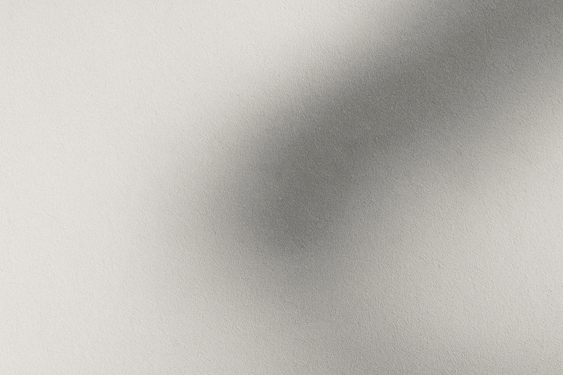 Abstraktes Licht-Schatten-Bild: helle Fläche mit sanftem grauen Schattenverlauf, der wirkt wie eine Andeutung eines Raumes hinter der Sprache; ruhig, minimalistisch, Ombra-Celeste-Atmosphäre.