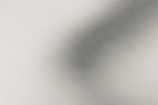 Abstraktes Licht-Schatten-Bild: helle Fläche mit sanftem grauen Schattenverlauf, der wirkt wie eine Andeutung eines Raumes hinter der Sprache; ruhig, minimalistisch, Ombra-Celeste-Atmosphäre.