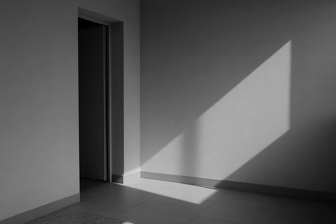 Heller Innenraum mit einfallendem Sonnenlicht; geometrische Schatten auf Boden und Wand, kein Mensch, keine Bewegung – ein stiller Übergang aus Licht und Fläche.