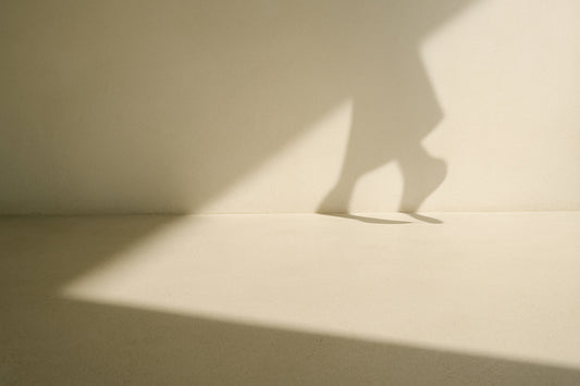 Helle, offene Fläche mit sanften Schatten, die einen Moment des Übergangs und der stillen Bewegung zwischen zwei Schritten andeutet.