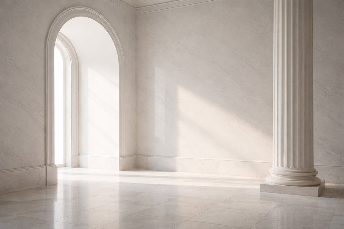 Moderner, luxuriöser Innenraum mit hellem weißem Marmor, klaren Linien und eleganter klassischer Architektur; weiches Tageslicht fällt seitlich ein, ruhige Atmosphäre, zeitgenössischer High-End-Stil