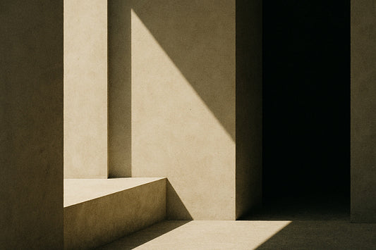 Minimalistische architektonische Szene: klare geometrische Formen, ein breiter Pfeiler im Sonnenlicht, daneben ein tiefdunkler Durchgang. Eine diagonale Lichtkante fällt über die Wand und den Stufenblock
